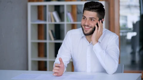 Happy middle eastern handsome bearded businessman talking on the phone and sm Stock Footage 124369309