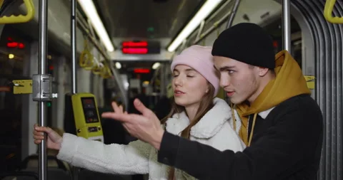 Happy millennial couple talking while going on public transport. Young man and 動画素材 136825327