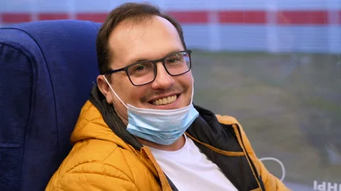 Happy millennial man rides train and smiles at the camera after lowering a Stock Footage 169274460