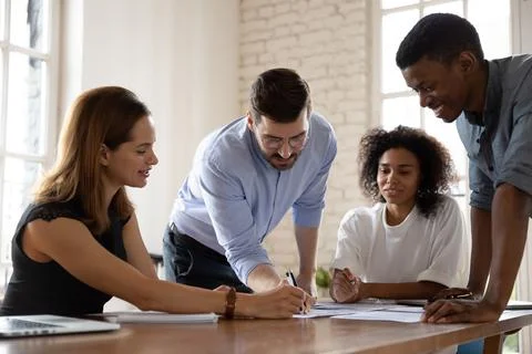 Happy millennial multiracial business people discussing project development Stock Photos