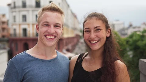 Happy mixed race guy and girl smiling at urban street on summer Stock Footage 94429575