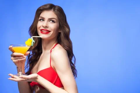 Happy model in red bikini presenting exotic cocktail Stock Photos