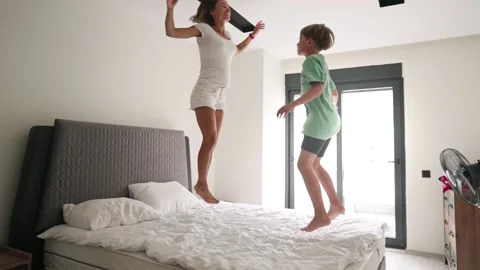 Happy mom have fun jumping with little son on bed. Stock-Footage 194890197