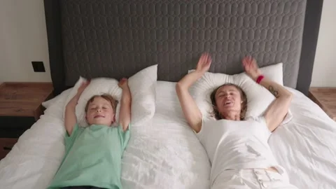 Happy mom have fun jumping with little son on bed. 스톡 동영상 201070885