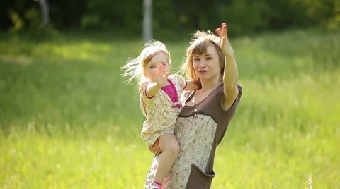 Happy mother and child waving his hand in the park Stock Footage