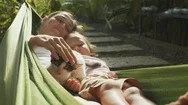 Happy Mother And Daughter Relaxing Together In A Hammock At Garden In Summer Day Stock Footage