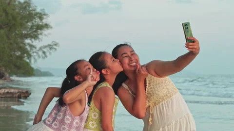 Happy mother and daughters taking selfie with smartphone on beach during summer Vídeo Stock 340185353
