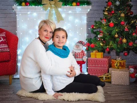 Happy mother and her cute little daughter in front of the Christmas tree Stock Photos