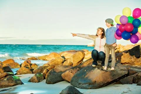 Happy mother and son having great time on the beach in sunset light Stock Photos
