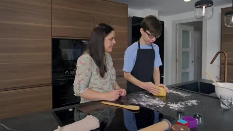 Happy mother and son preparing dough with rolling pin in modern kitchen Stock Footage 303144663