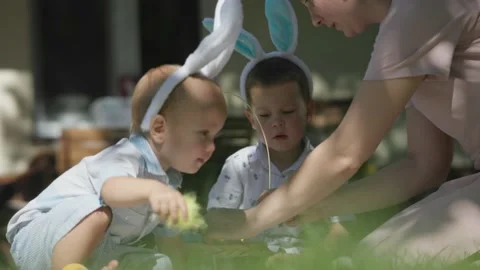 Happy mother having Easter picnic together children on grass in backyard park Stock Footage 232635480