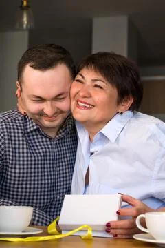 Happy mother hugging son while holding present. Mother's day or 8 march conce Stock Photos
