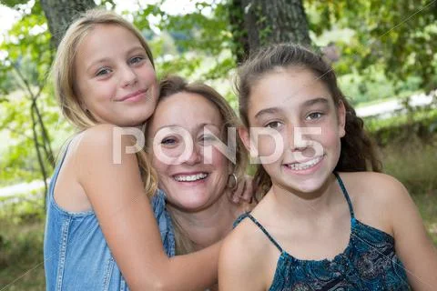 Happy mother hugging two young girl, smiling faces, Stock Photos
