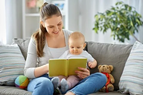 Happy mother reading book to little baby at home Stock Photos