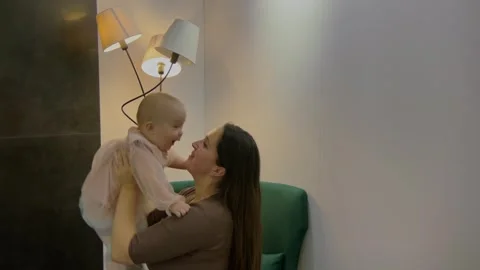 Happy mother throw up and catch her daughter. Young woman playing with baby Video stock 250178490
