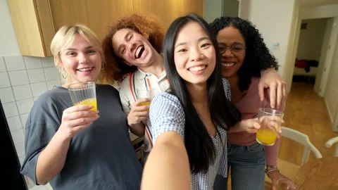 Happy multi ethnic friends taking selfies while drinking orange juice Stock Footage 306216220