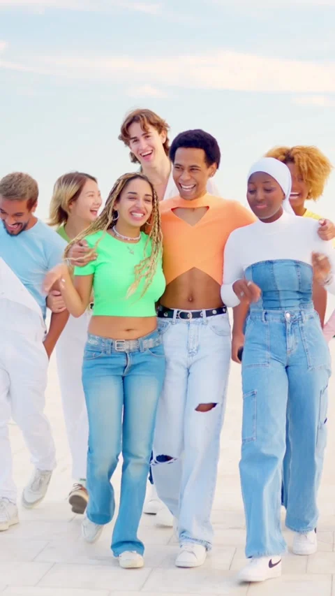 Happy multi-ethnic friends walking together along a promenade Stock Footage 256097152