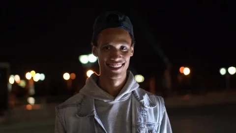 Happy Multi-Ethnic guy smiling on the background of the night city, 4x slowmo Stock Footage 115670469