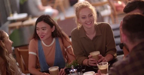 Happy multi-ethnic hipster friends relaxing and drinking coffee at cafe Stock Footage