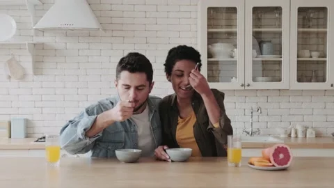 Happy multiethnic couple having breakfast in kitchen. Young African American Video stock 236486242