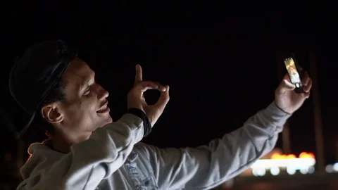 Happy Multiethnic guy take a selfie at night time in the city, 4x slowmotion Stock Footage 115677075