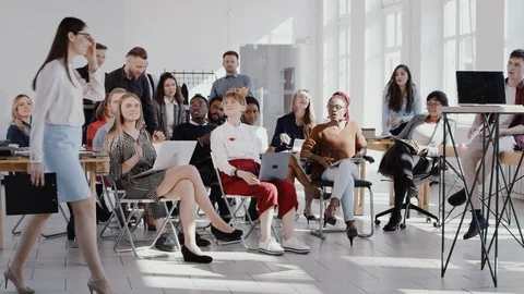 Happy multiethnic team applause to young female coach entering modern trendy Stock Footage 114605802