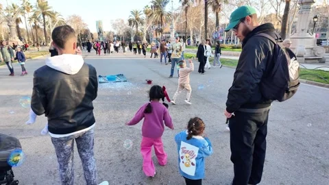 Happy multinational children playing with soap bubbles on a busy street, 4K Stock Footage 271131638