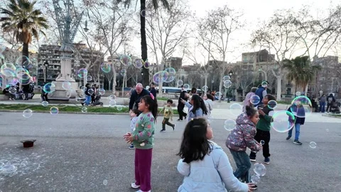 Happy multinational children playing with soap bubbles on a busy street, 4K Stock Footage 271131702