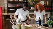 Happy Multiracial Couple Cooking Healthy Food In Their Loft Kitchen At Home Stock Footage