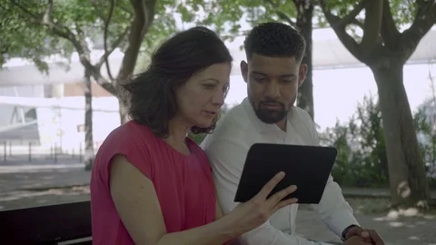 Happy multiracial couple using tablet in park. Stock Footage 108817818