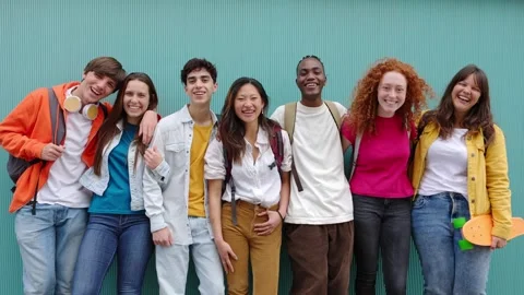 Happy multiracial students standing over isolated blue background Stock Footage 241261004