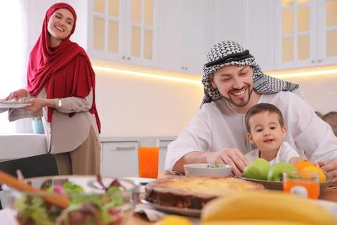 Happy Muslim family eating together in kitchen Stock Photos