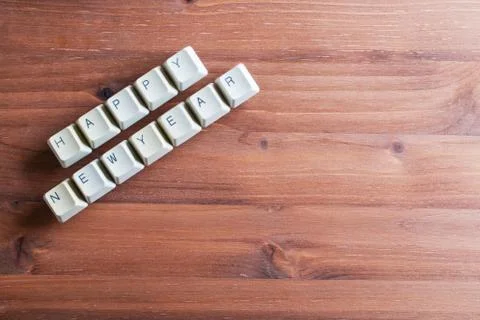 Happy new year card concept on computer keyboard keys on a wooden background Stock Photos