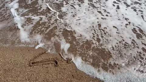 Happy New Year concept. Text 2024 handwritten in sand surface. Blue ocean w.. Stock Footage 251801661