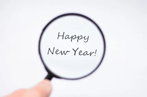 Happy new year through magnifying glass on white background Stock Photos