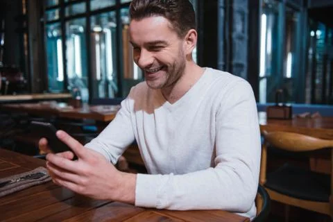 Happy nice man looking at the screen of his smartphone Stock Photos