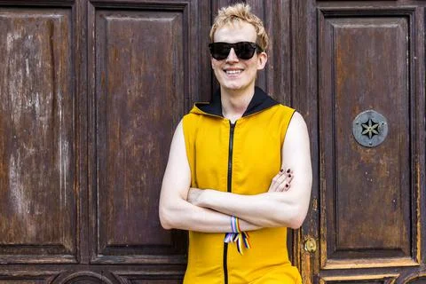 Happy non binary man against old door Foto stock