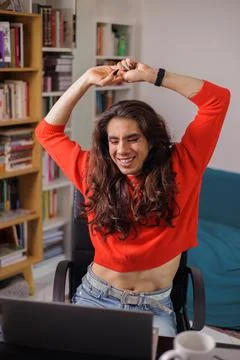 Happy non-binary person stretching to start their work day Stock Photos