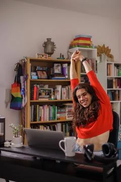 Happy non-binary person stretching to start their work day Stock Photos