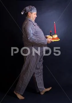 Happy Obese Man In Pajamas Carries Food