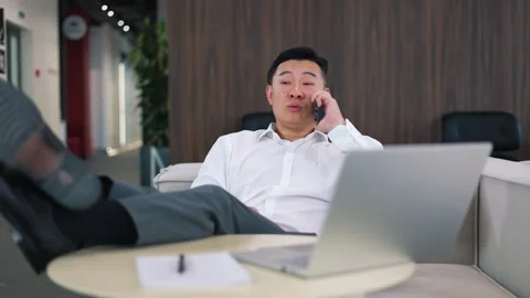 Happy office man having mobile conversation with coworkers at business center Stock Footage 251785552