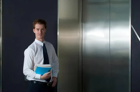 Happy Office Worker Waiting Elevator Horizontal A happy and smiling office... Stock Photos