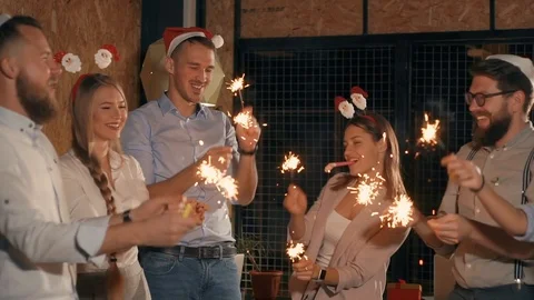 Happy office workers are playing with sparklers in Christmas party Stock Footage 99729826