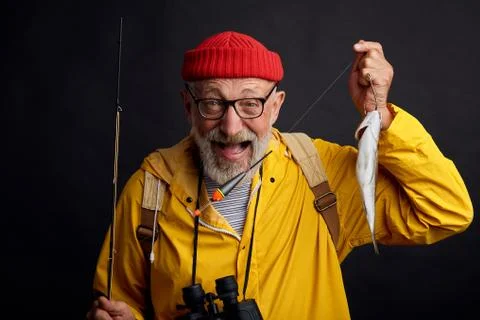 Happy old bearded fisherman is happy as he has cought fist fish Stock Photos