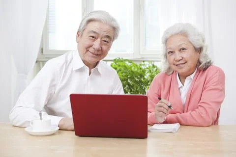The happy old couple are using laptops Stock Photos