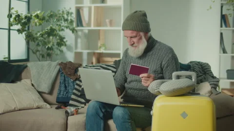 A Happy Old Man Enters Data From His Passport Into a Laptop. Stock Footage 249586787
