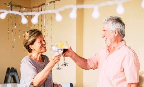 Happy old senior caucasian couple celebrate together with a cup of wine - peo Stock Photos