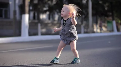Happy One Year Old Cute Girl Making Her First Steps on City Road Stock Footage 66549320
