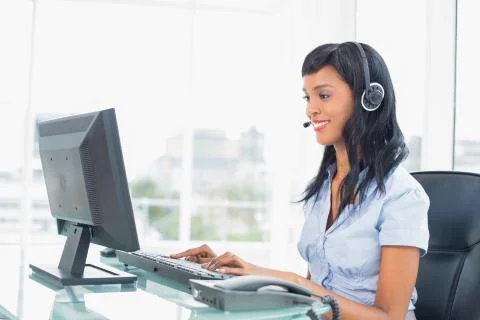 Happy operator typing on her computer Stock Photos