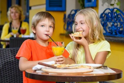 Happy or satisfied boy width girl eating pizza and drinking juice Foto stock